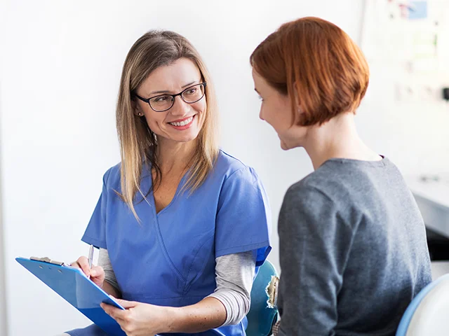 Untersuchung und Beratung: Zahnarzt erklärt einer Patientin den Befund